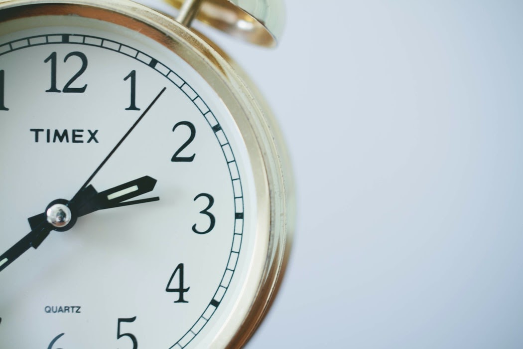 Close-up of an alarm clock symbolizing the importance of maintaining regular working hours and setting boundaries in remote work for better time management.